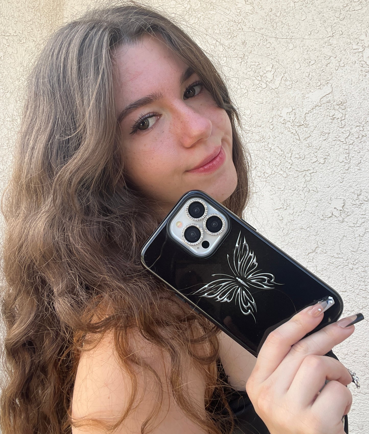 Phone case chrome butterfly on black background. Edgy, gothic, emo design that is very protective. Fits iPhone, Samsung & Google Pixel models. up close modeled