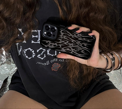 Person holding a phone case with a black background with cyber cigilism metal silver daggers